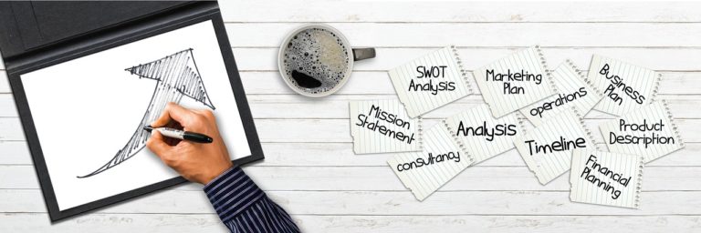 man writing in notebook with coffee